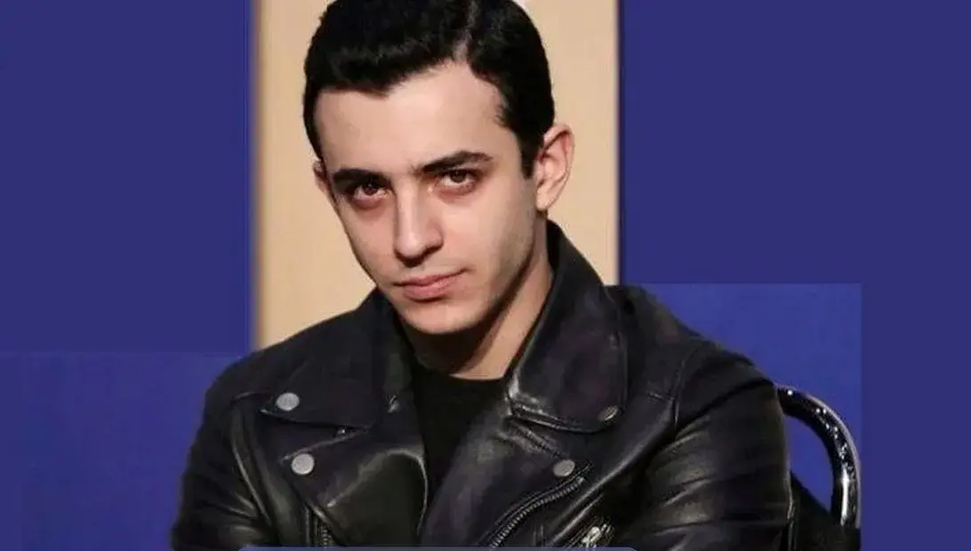 چیدمان منزل مجردی علی شادمان در برج آ اس پ / فرش دستبافت هریس،مبلمان چرم قهوه ای، کف پوش های چوبی و پنجره های بزرگ با ویو ابدی