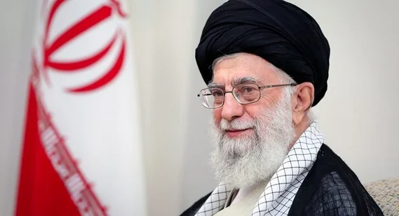 رهبر شهید انقلاب با لباس ارتشی و دوربین در سنگر در دهۀ ۶۰