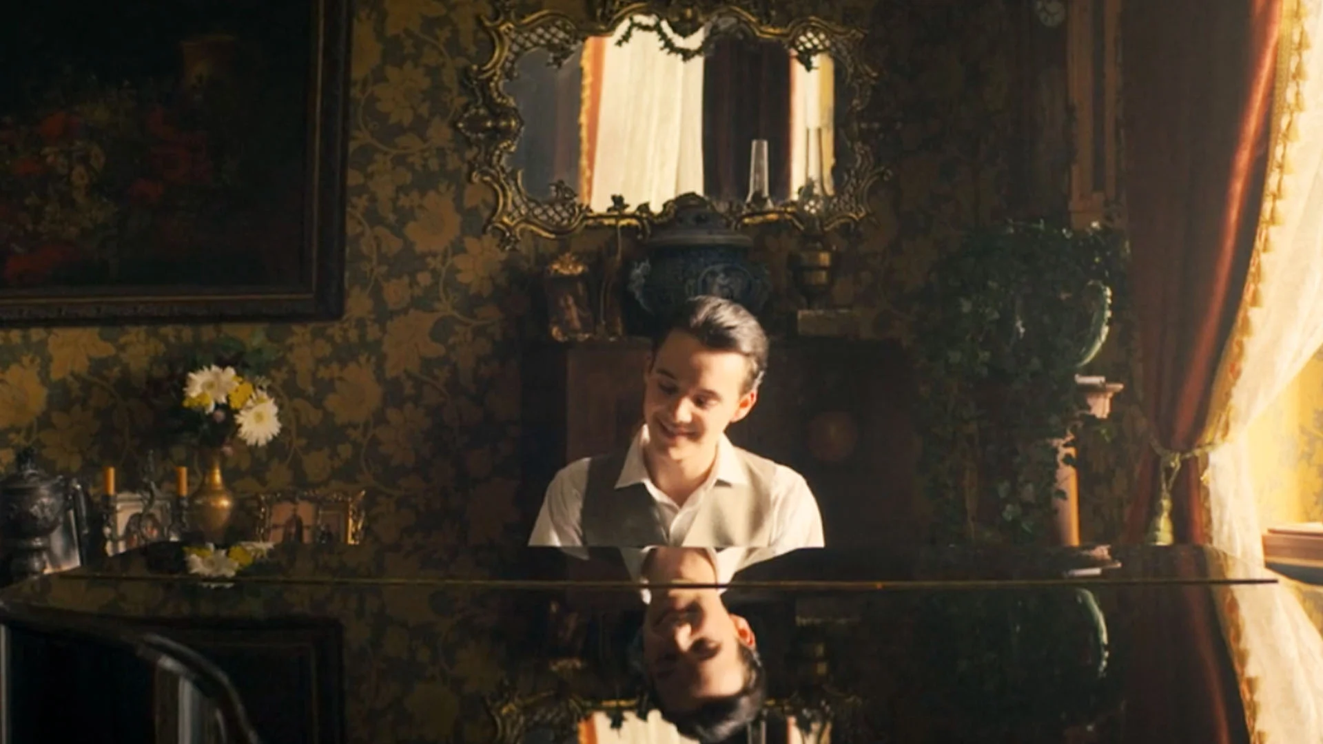 Pianist Smiling While Playing a Grand Piano in a Vintage Ornately Decorated Parlor with Floral Wallpaper and a Gilded Mirror Behind Him
