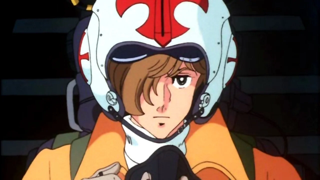 Area 88 Animated Character in a White Helmet with Red Markings and an Orange Flight Suit Looking Downward with a Serious Expression in a Cockpit