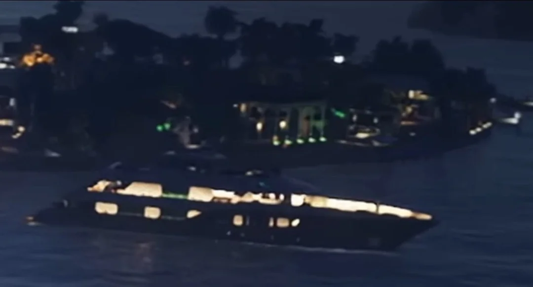 Nighttime Scene of a Lit Passenger Boat Sailing on Dark Water Near a Shore with Illuminated Buildings and Trees in the Background oops the Previous Contains a Stray Character Corrected