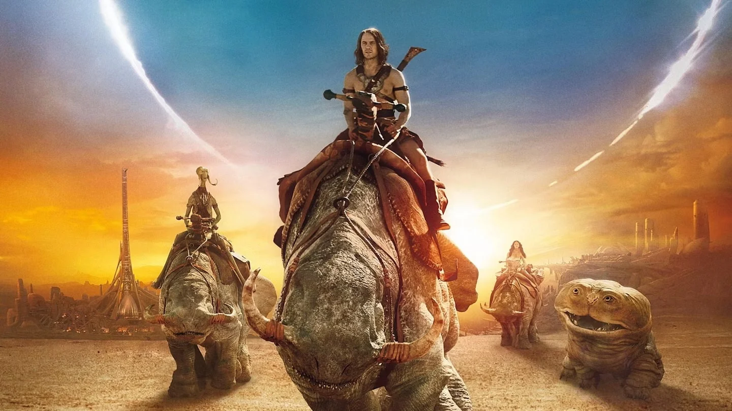 John Carter a Shirtless Man Rides a Large Dinosaur at Sunset Followed by Riders on Dinosaur Mounts Across a Dusty Desert Toward a Distant Futuristic City Skyline