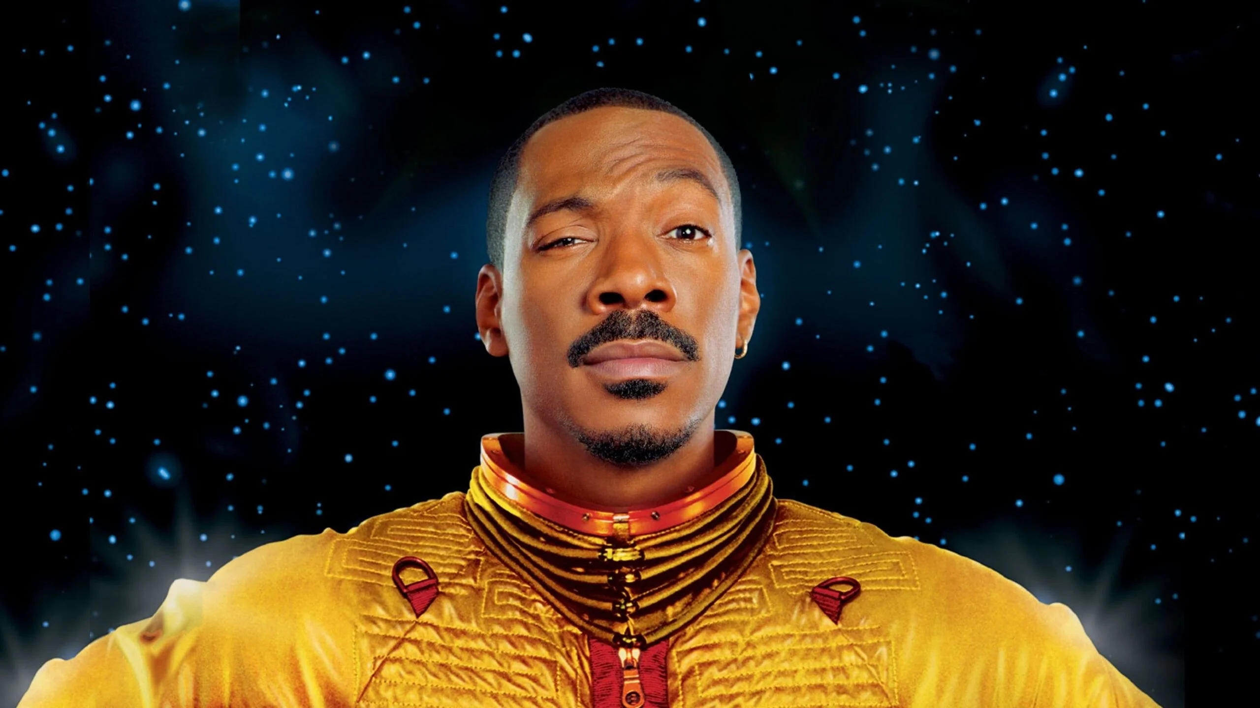 the Adventures of Pluto Nash Close up Portrait of a Man in a Bright Yellow Textured Suit with a Goatee Against a Starry Blue Space Background